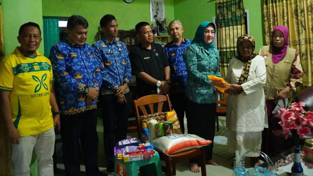 Ketua TP PKK, Maria, saat serahkan bantua n sembako pada salah seorang lansia.